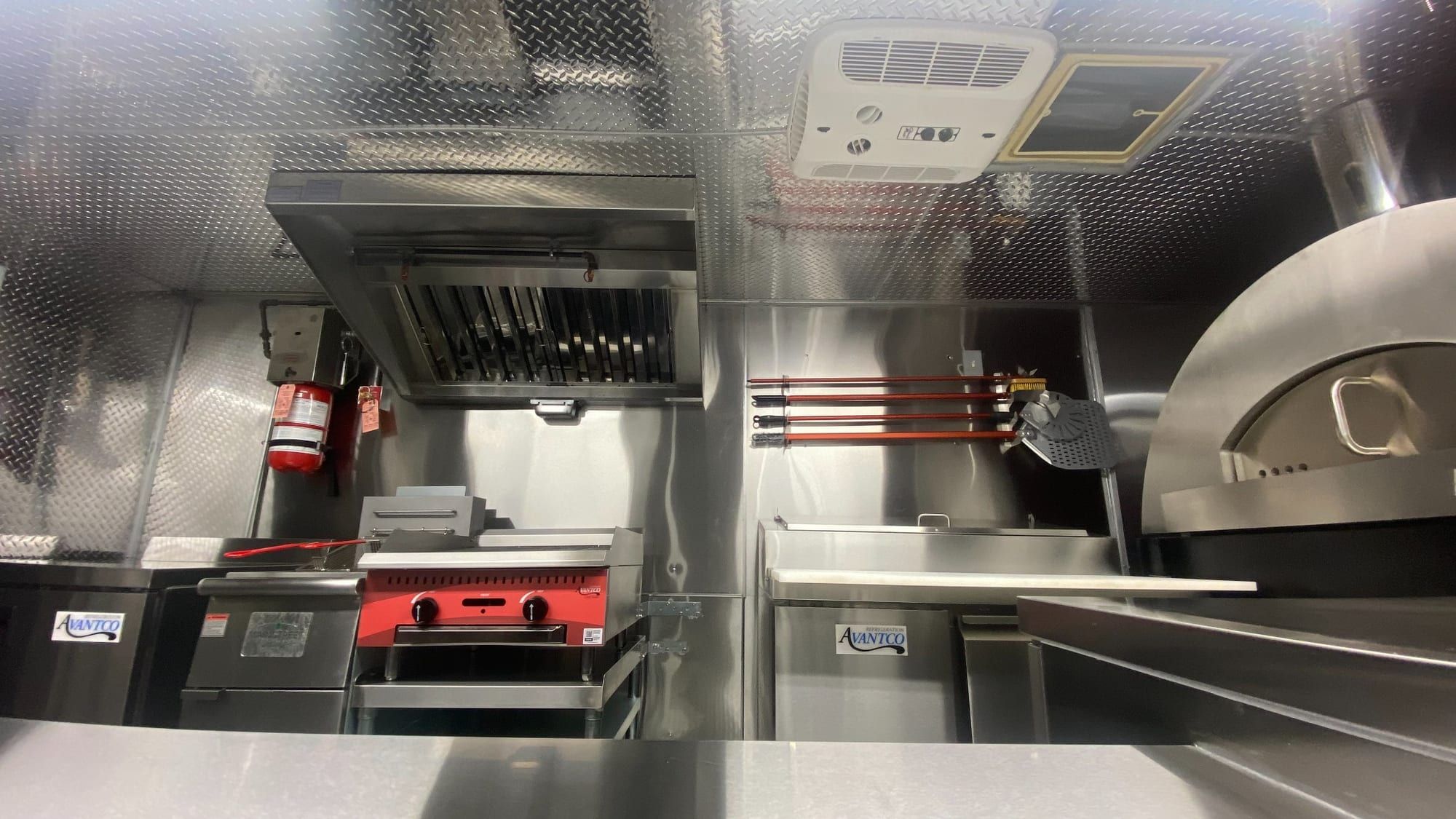Pizza truck cook line with commercial hood, charbroiler and pizza oven
