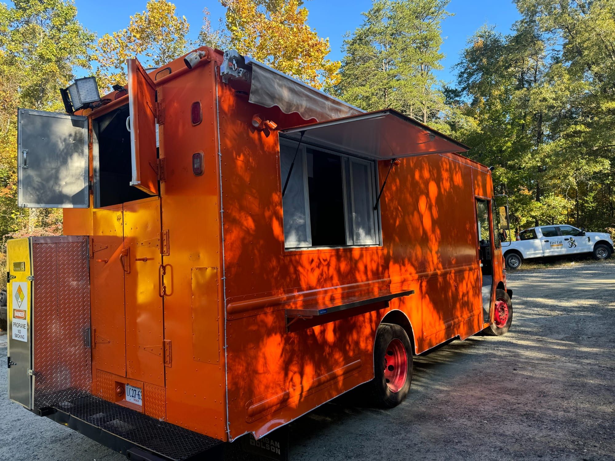 Taco truck naranja con la ventana de servicio y el toldo abiertos