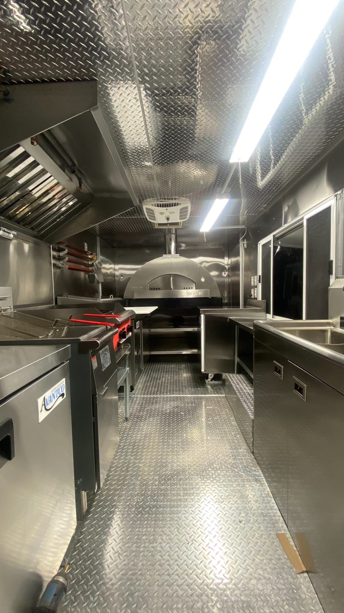 Pasillo de acero inoxidable del pizza truck con el horno de pizza al fondo