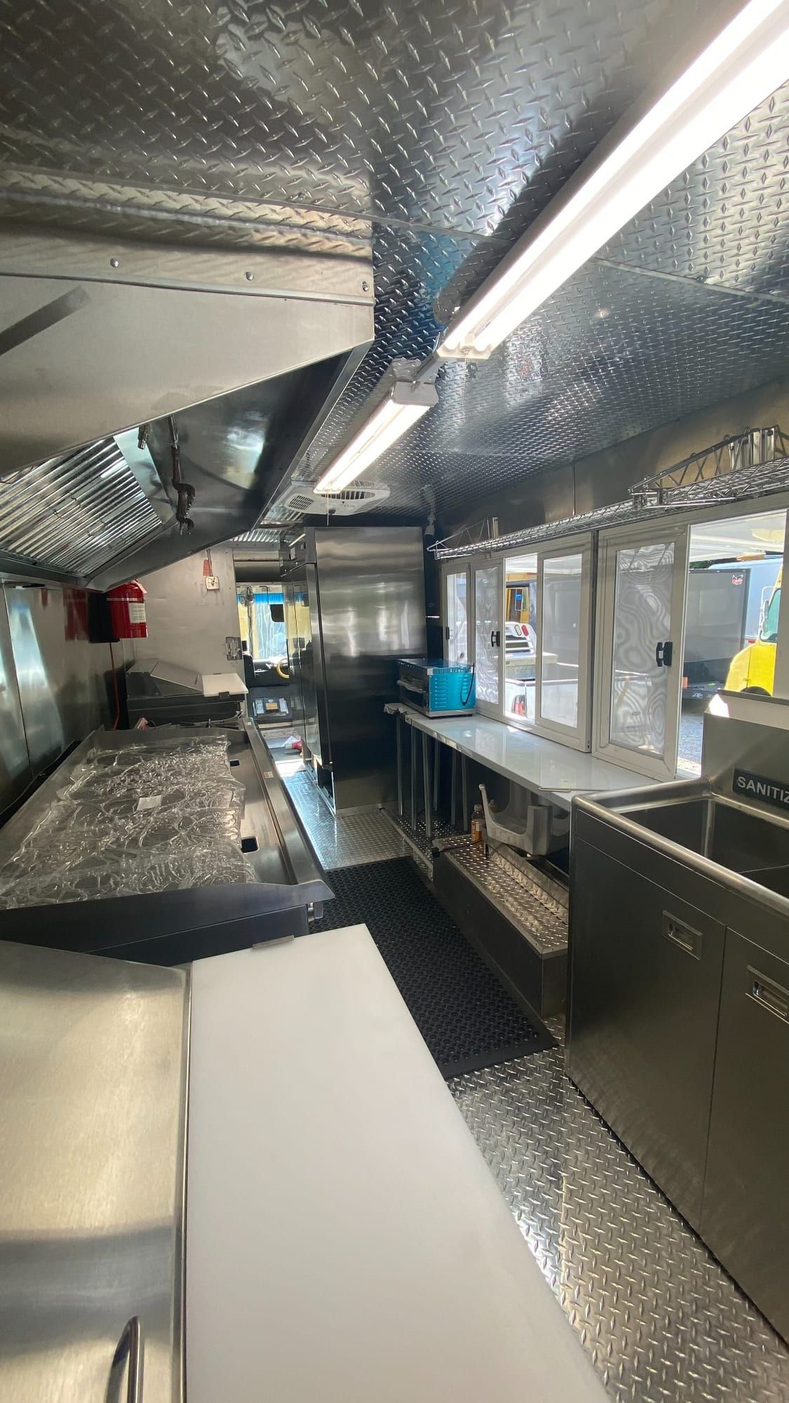 Plancha, campana y mostrador de servicio en la cocina de Tacos Los Primos