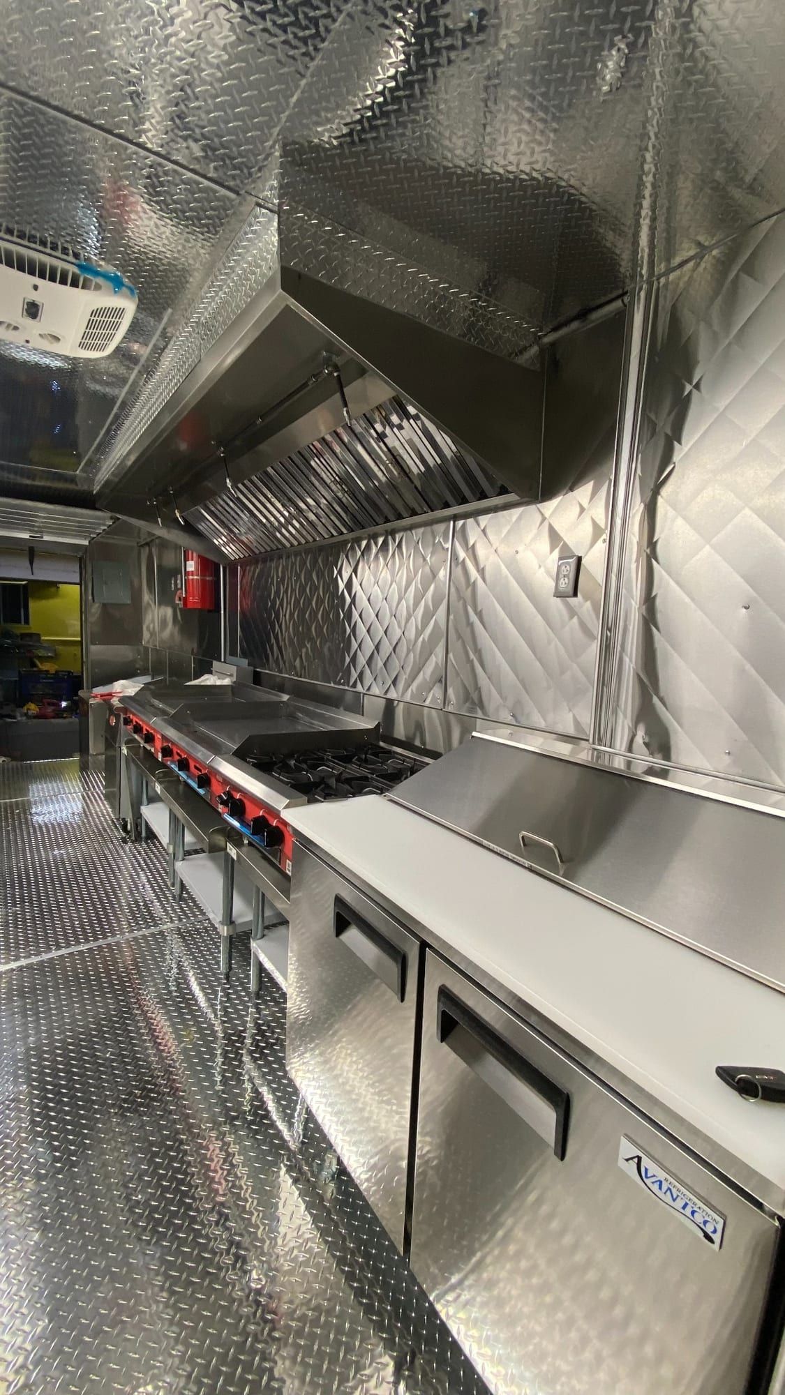 Cook line with commercial hood and refrigerated prep in the Mexican food truck