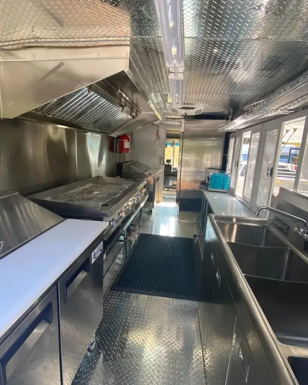 Tacos Los Primos — kitchen galley with refrigerated prep and griddle