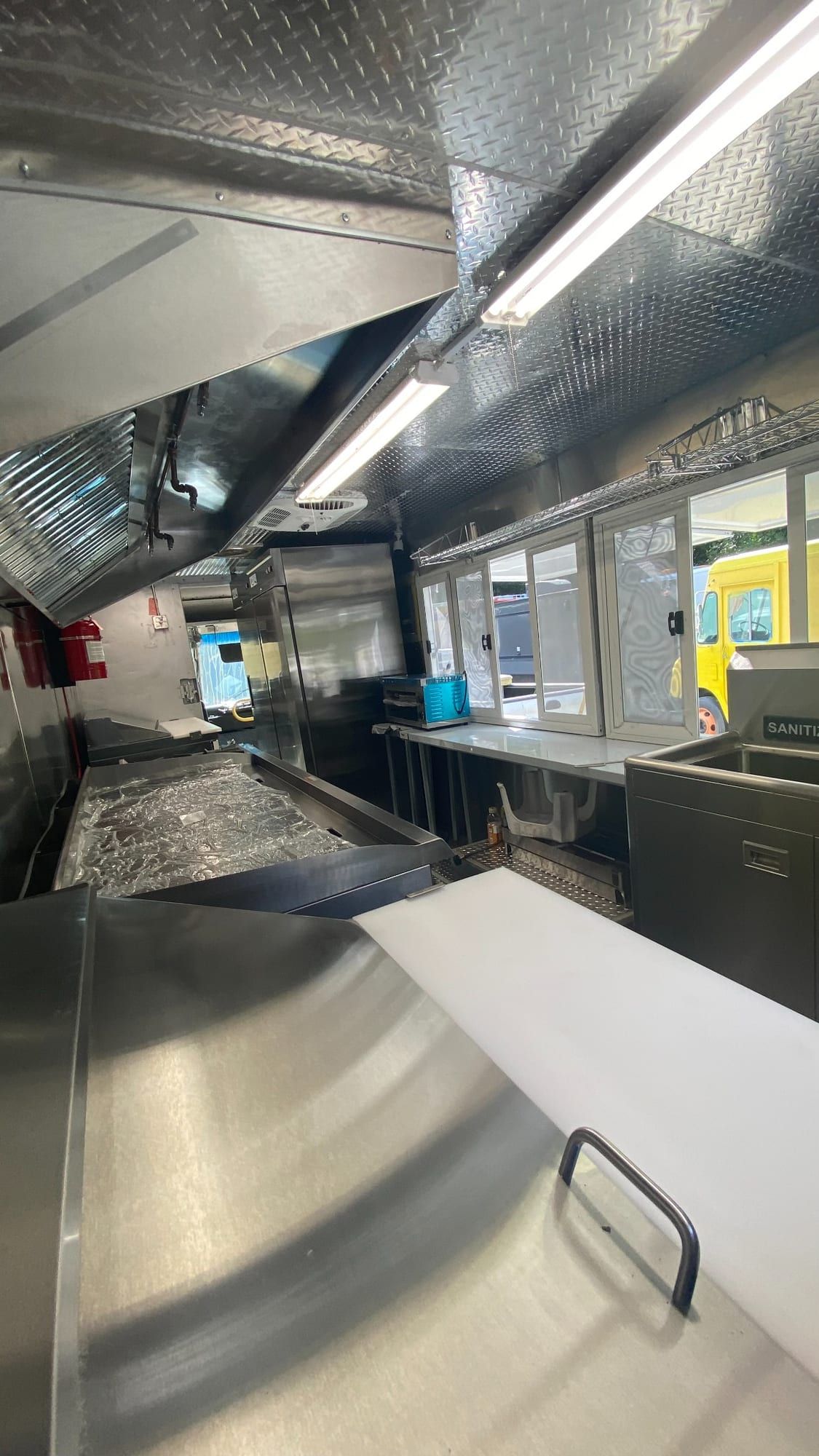 Prep area leading to the service windows in the Tacos Los Primos kitchen