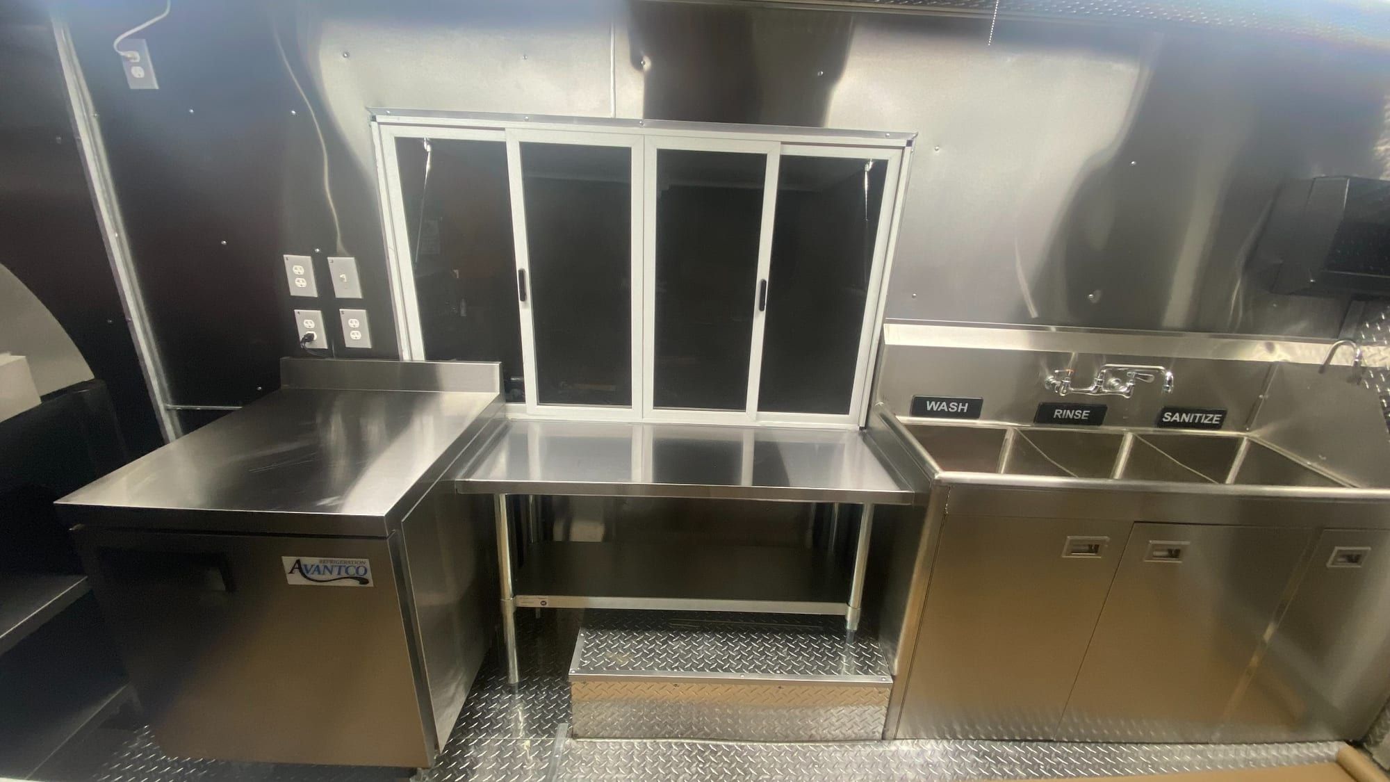 Línea de servicio de acero inoxidable con ventana corrediza y fregadero de tres compartimentos en un pizza truck construido por MKP