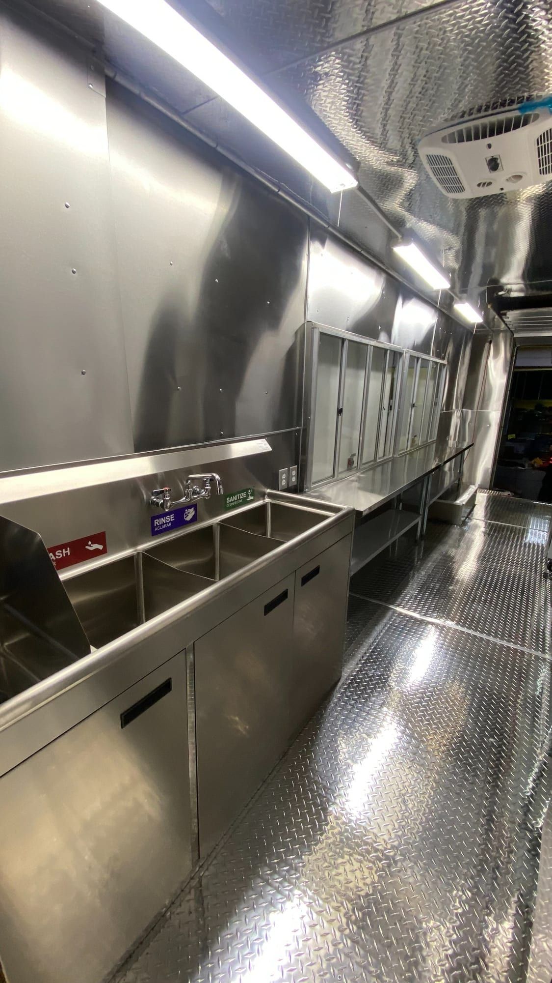 Cocina de food truck de acero inoxidable con fregadero de tres compartimentos y ventanas de servicio